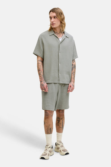Groen hemd met korte mouwen van ORIGINALS by JACK & JONES, gedragen met een bijpassende korte broek en witte sokken.