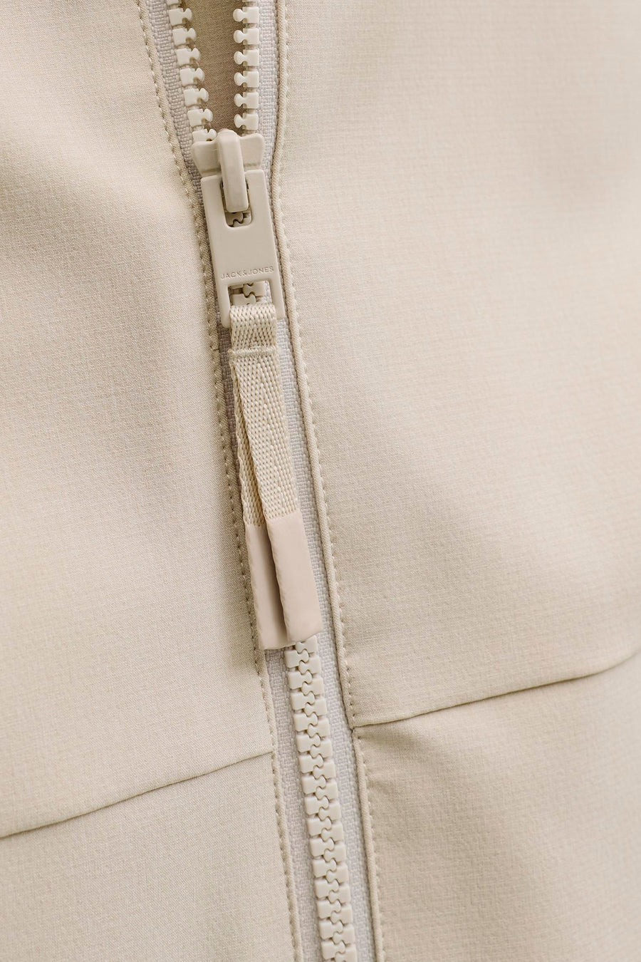 Korte ecru jas van PREMIUM by JACK & JONES, met sluiting van een crèmekleurige ritssluiting.
