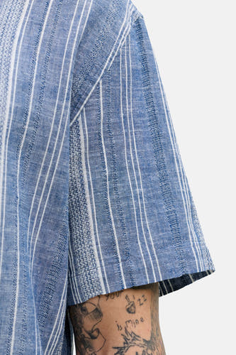 Blauw, kort mouw overhemd van PREMIUM BLUE by JACK & JONES, met een gestreept patroon en zichtbare tatoeages.
