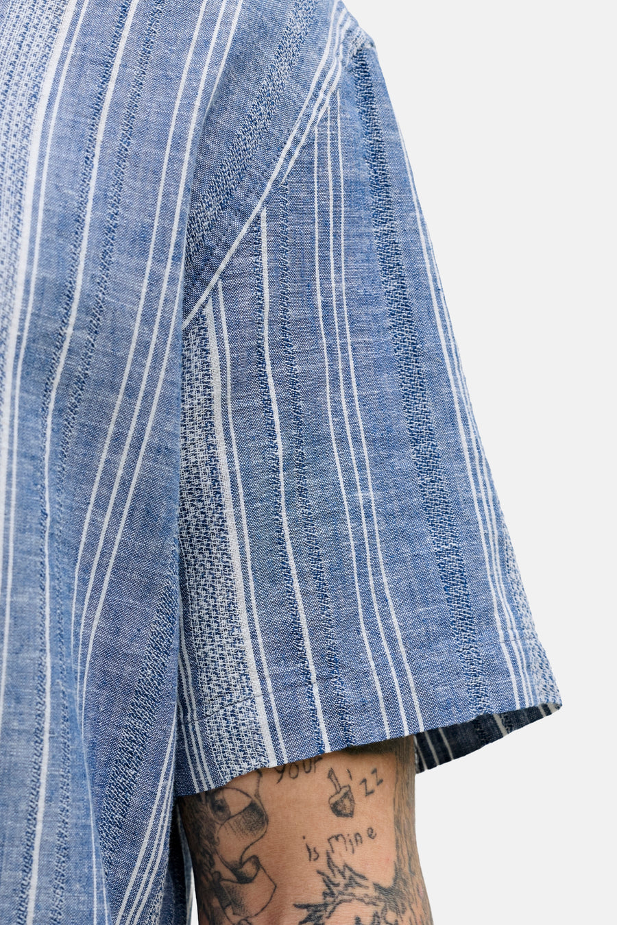 Blauw, kort mouw overhemd van PREMIUM BLUE by JACK & JONES, met een gestreept patroon en zichtbare tatoeages.
