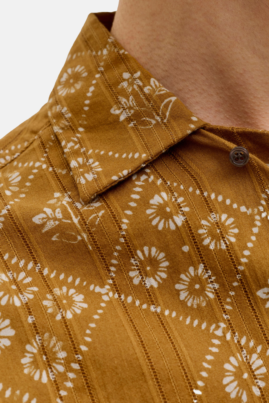 Chemise jaune de PREMIUM by JACK & JONES avec motif à fleurs et pois blancs, texture rayée et un bouton foncé, gros plan.