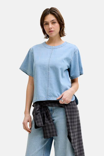 Chemisier en jean bleu clair à manches courtes de JJXX, avec une chemise nouée décontractée autour de la taille et un jean large.