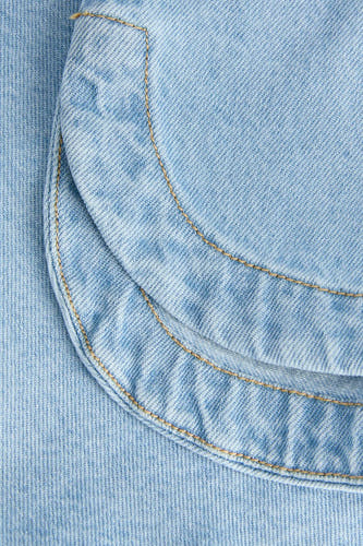 Chemisier en jean bleu clair (manches courtes) de JJXX, gros plan avec coutures et poche arrondie.