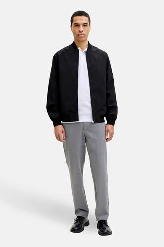 Grijze broek van JACK & JONES JEANS INTELLIGENCE, gecombineerd met een wit poloshirt en een zwart bomberjack.