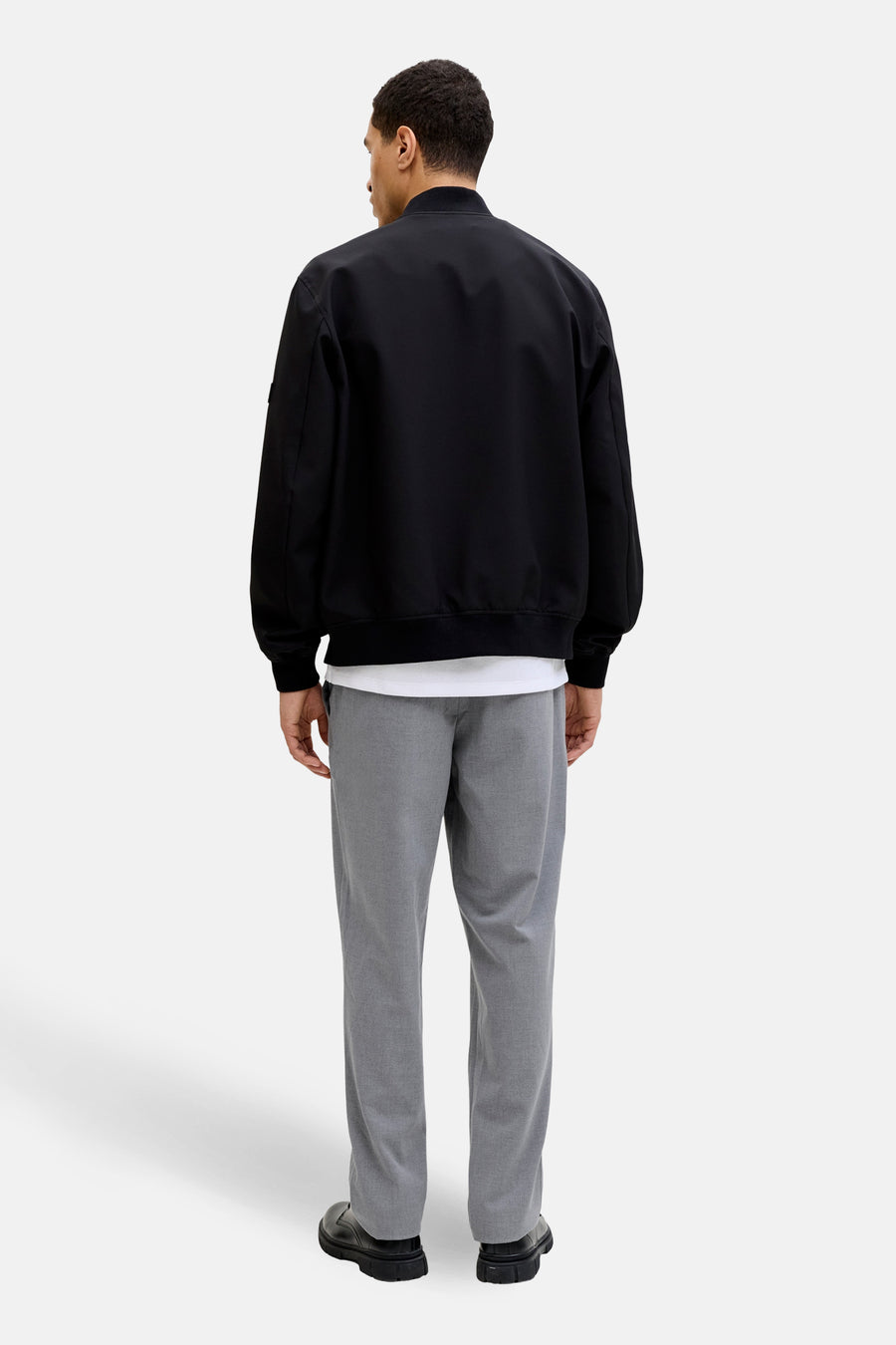 Pantalon gris de JACK & JONES JEANS INTELLIGENCE, vu de dos, combiné avec une veste noire et des chaussures noires.
