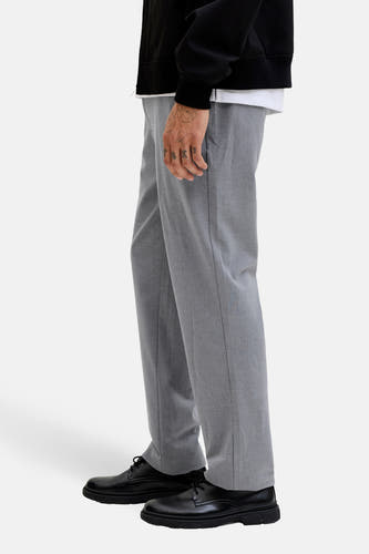 Pantalon gris de JACK & JONES JEANS INTELLIGENCE, avec un motif uni et des jambes droites, porté avec des chaussures noires.