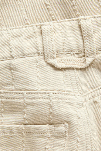 Pantalon écru de JJXX, avec passants de ceinture et coutures ton sur ton discrètes.