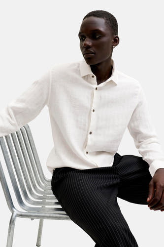 Wit hemd van PREMIUM by JACK & JONES met lange mouwen en bruine knopen, gedragen door een man.