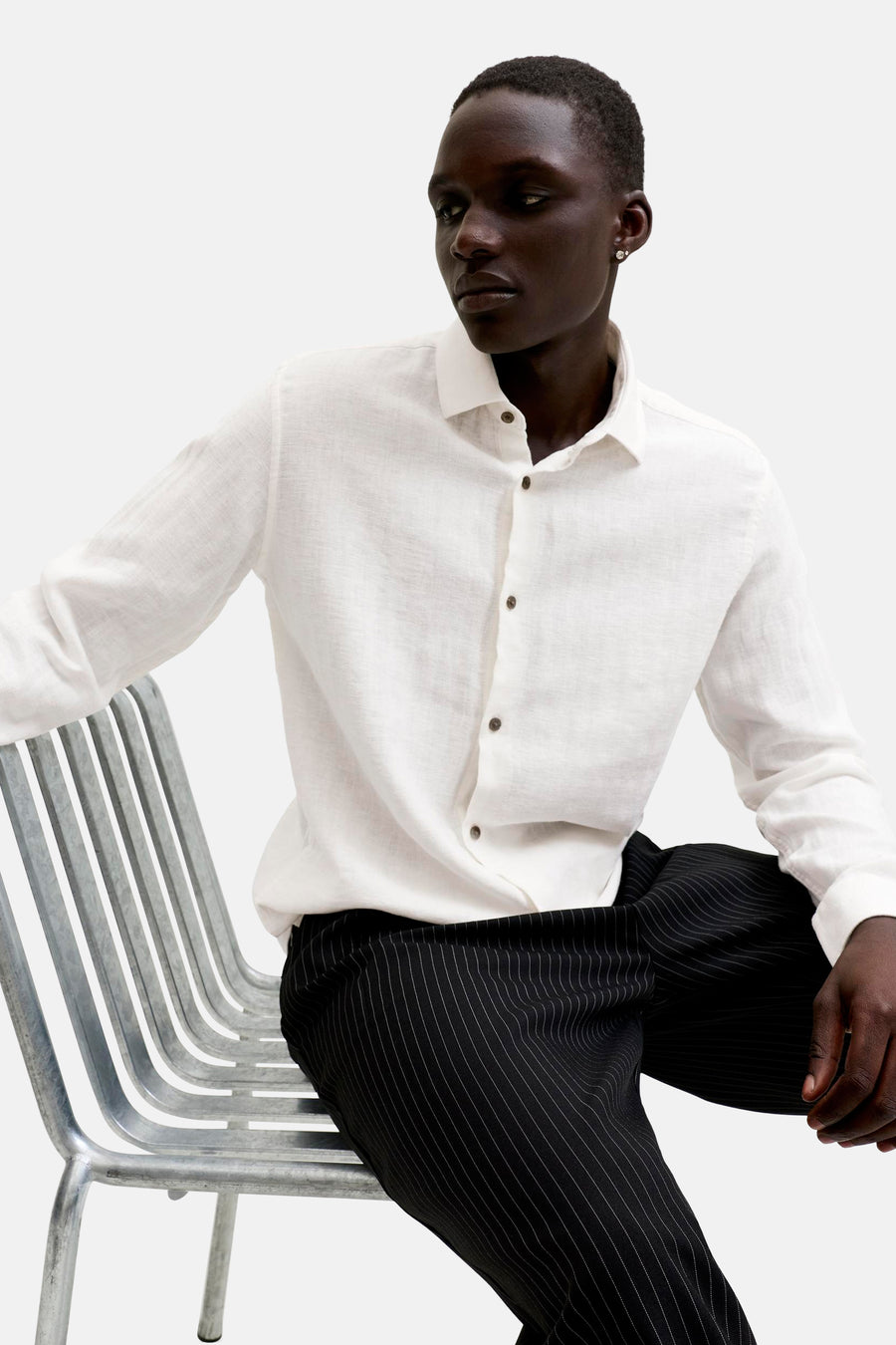 Wit hemd van PREMIUM by JACK & JONES met lange mouwen en bruine knopen, gedragen door een man.