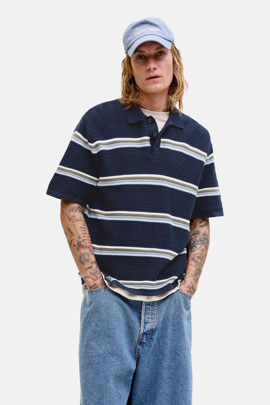 Polo bleue de ORIGINALS BY JACK & JONES, à rayures horizontales et coupe décontractée, portée avec un short en jean et des bottes marron.