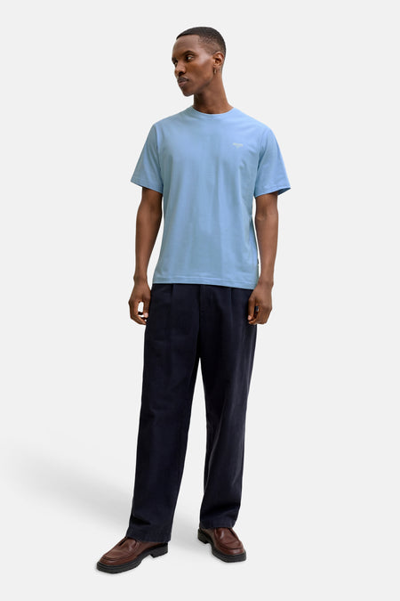 Blauw T-shirt met korte mouwen van PREMIUM by JACK & JONES, gedragen met een donkere pantalon en leren loafers.