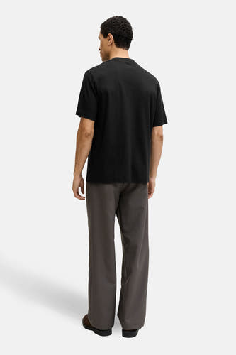 T-shirt noir à manches courtes de PREMIUM by JACK & JONES, vu de dos, avec pantalon et chaussures marron.