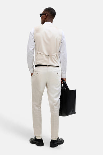 Ecru gilet van PREMIUM by JACK & JONES, met verstelbare riem aan de achterkant, gedragen over een wit overhemd en lichte broek.