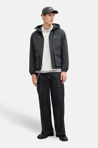 Witte sweater met ronde hals van ORIGINALS BY JACK & JONES, gedragen onder een jas met ruitpatroon, gecombineerd met een pet en donkere jeans.
