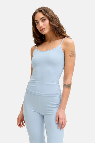 Blauwe top met spaghettibandjes van JJXX, met subtiele tattoos op de armen.