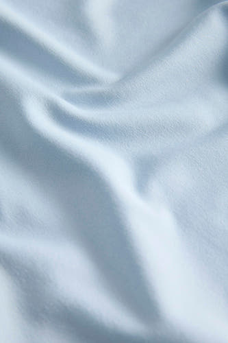 Blauwe top van JJXX, met een zachte, geweven textuur en elegante draperingen.
