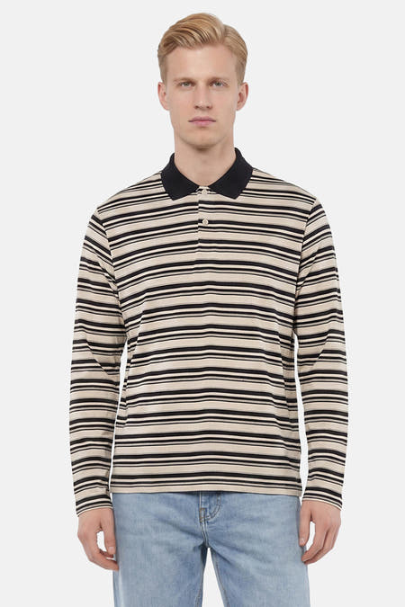 Gestreepte polo met lange mouwen in zwart en beige van ORIGINALS BY JACK & JONES, met een zwarte kraag, knopen en gedragen met een lichtblauwe jeans.