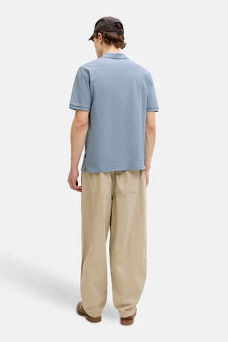 Blauwe polo van PREMIUM BLUE by JACK & JONES, gezien van achteren, met kaki broek en bruine schoenen.