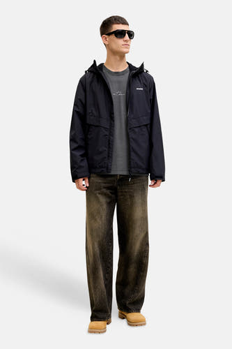 T-shirt noir à manches courtes de CORE BY JACK & JONES, avec un imprimé discret, porté sous une veste noire.