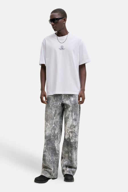 Wit T-shirt van CORE BY JACK & JONES, met een kleine print op de borst, gedragen met een zilveren ketting en grijze jeans.
