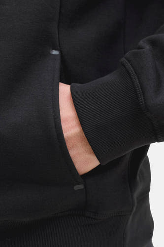Sweat-shirt noir de CORE BY JACK & JONES, avec une main dans la poche et un poignet côtelé à la manche.