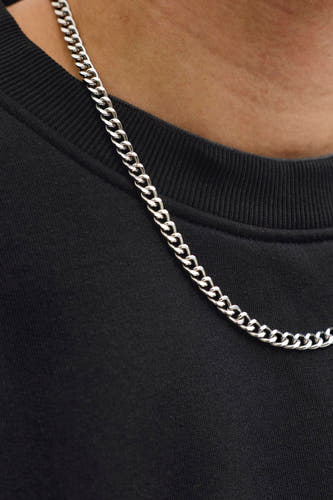 Pull noir à col rond de CORE BY JACK & JONES, porté avec une chaîne argentée.