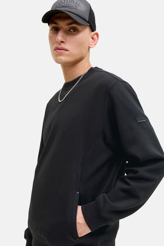 Pull noir à col rond de CORE BY JACK & JONES, avec une chaîne argentée et une casquette noire.