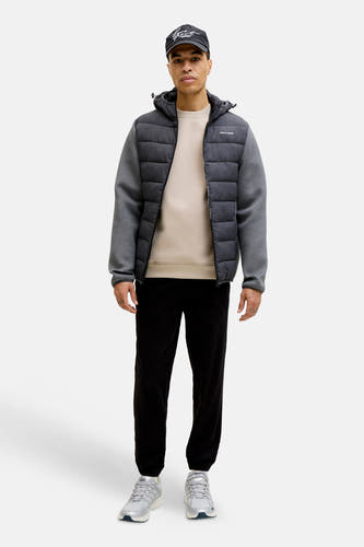 Beige sweater van CORE BY JACK & JONES, met lange mouwen en ronde hals, gecombineerd met een zwarte jas en joggingbroek.