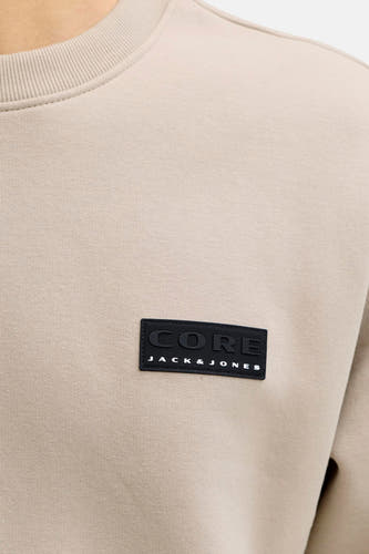 Beige sweater van CORE BY JACK & JONES, met zwarte merklabel op de borst en ronde hals.