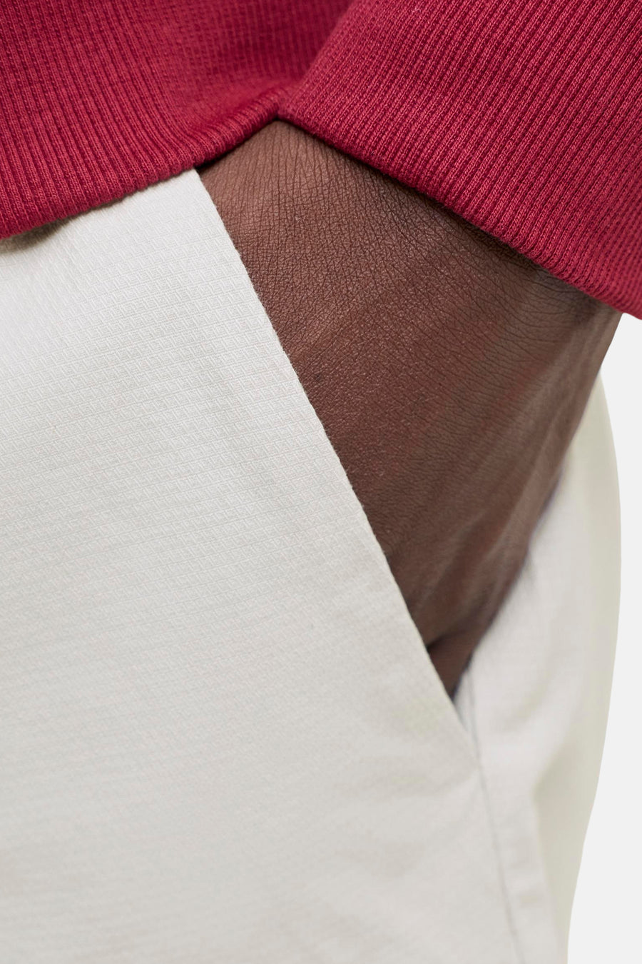 Beige short van JACK & JONES JEANS INTELLIGENCE met subtiel geweven patroon, zak met hand en rood geribbeld shirt.