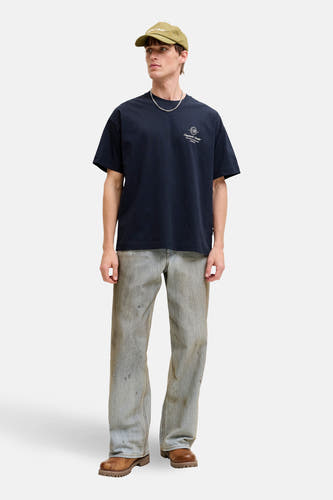 Blauw T-shirt met korte mouwen van Originals by Jack & Jones, met een klein logo en gedragen met een pet, ketting, jeans en bruine laarzen.