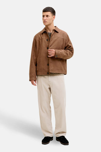 Man met bruine jas en beige corduroy broek.