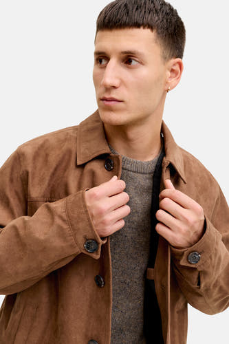 Bruine korte jas van PREMIUM by JACK & JONES, met een grijze trui en een gouden oorbel.
