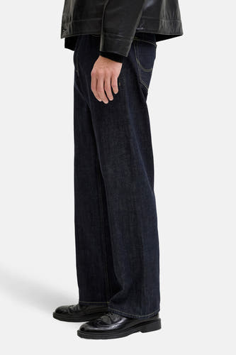Rechte jeans van donkerblauw denim van JACK & JONES JEANS INTELLIGENCE, met gele stiksels en zwarte schoenen.