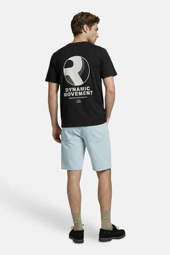 T-shirt noir JJREBEL avec grand imprimé graphique blanc d'un logo 'R' et le texte 'DYNAMIC MOVEMENT' dans le dos, porté par un homme en short en jean.