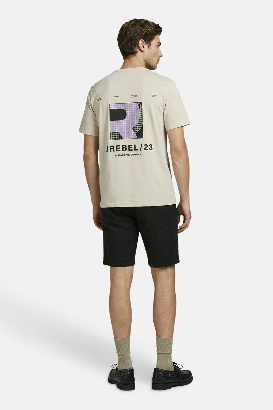 T-shirt beige de JJREBEL avec un logo graphique 'R' violet et noir dans le dos, porté par un homme avec un short noir.