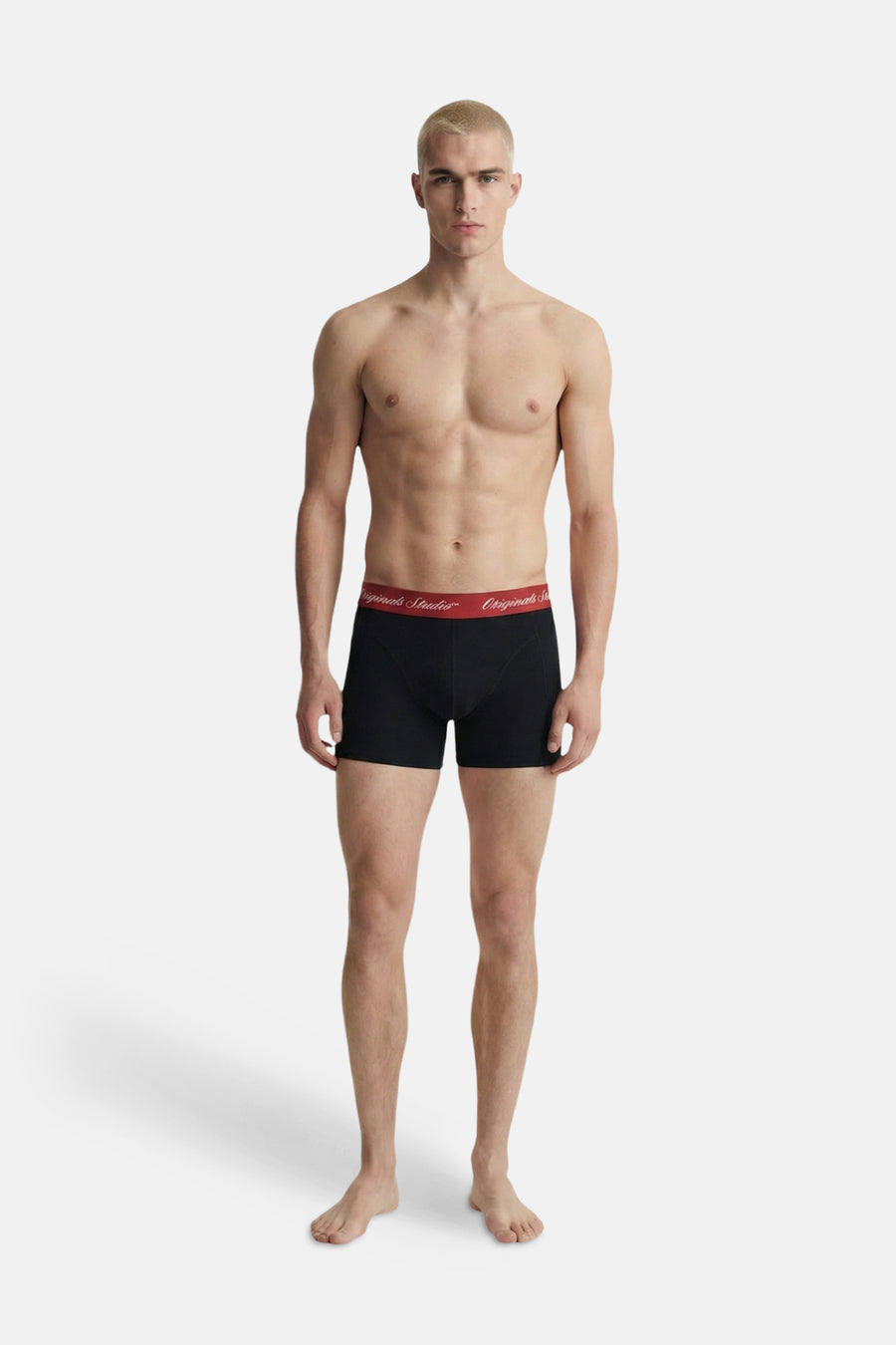 Zwarte boxershort van ACCESSORIES BY JACK & JONES met rode tailleband en wit 'Originals Studio' logo, gedragen door een model.