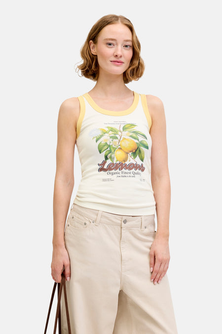 Ecru singlet van JJXX met gele biezen en een opdruk van citroenen, bladeren en bloemen.