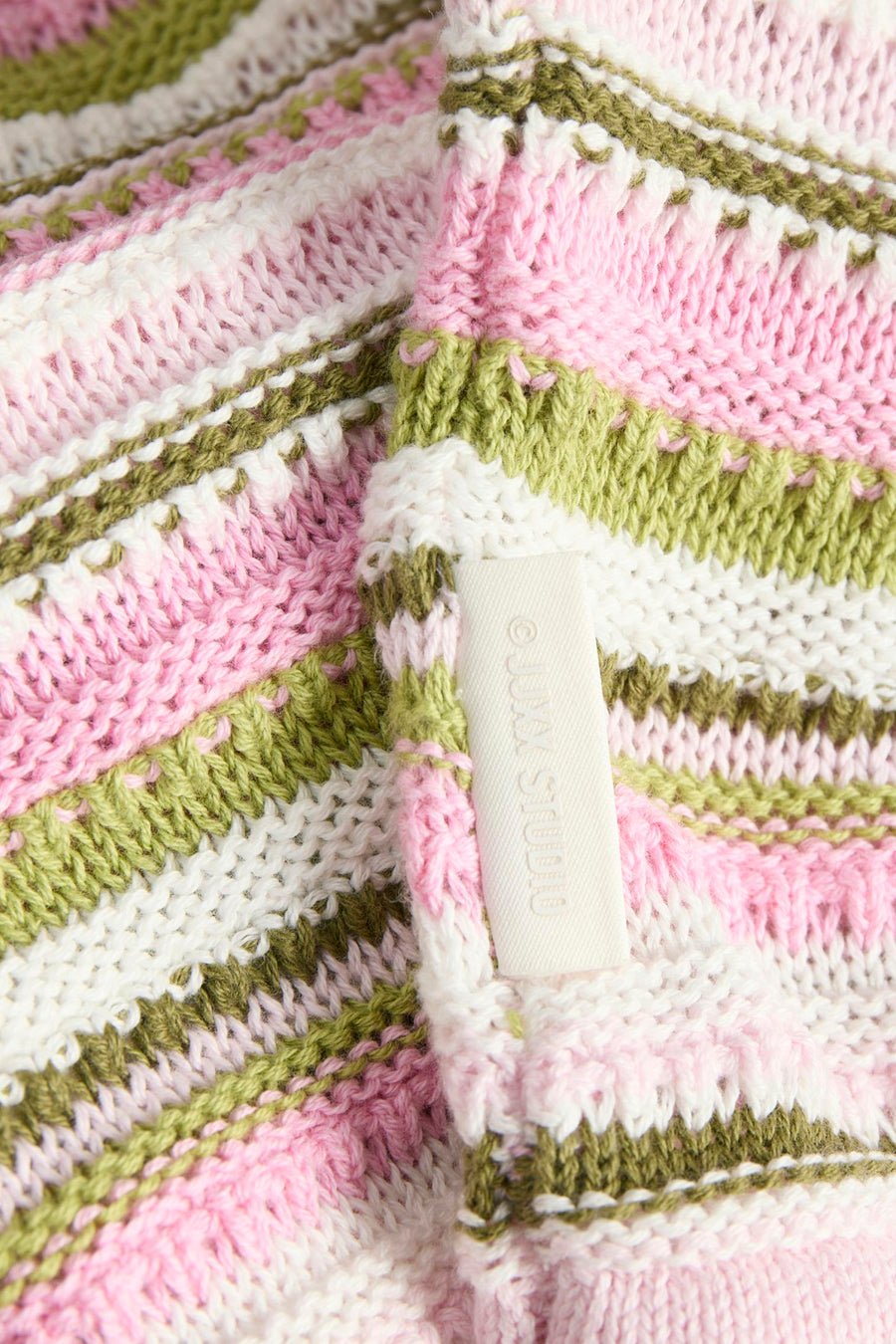 Multikleurige gebreide trui met ronde hals van JJXX, met roze, groene en witte strepen en zichtbare label in close-up.