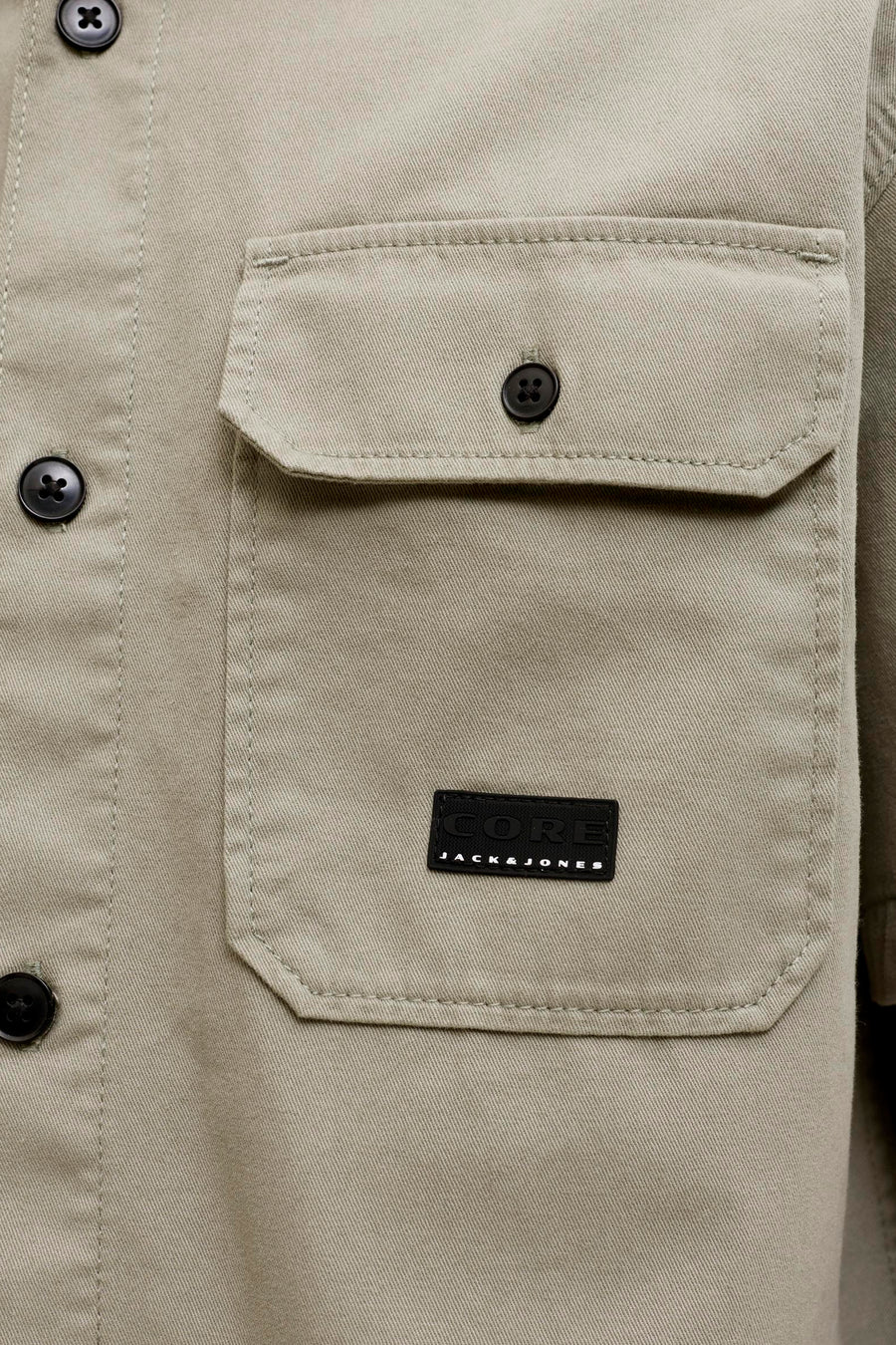Chemise beige à manches courtes de CORE BY JACK & JONES avec tissage diagonal, poche poitrine et logo noir.
