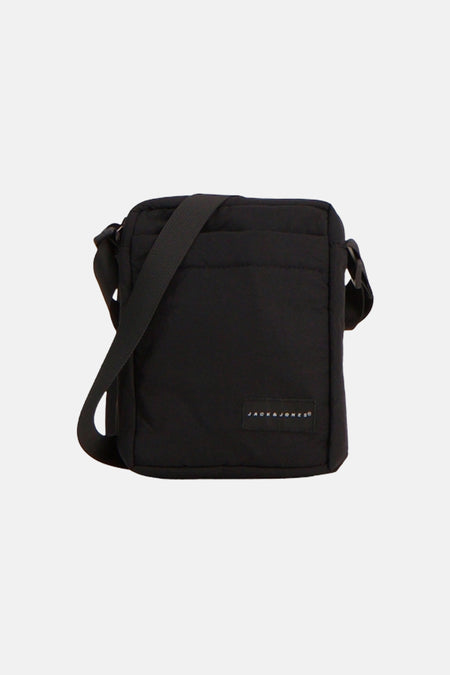 Zwarte schoudertas van JACK & JONES met logo-patch, gewatteerde bovenkant en verstelbare schouderband.