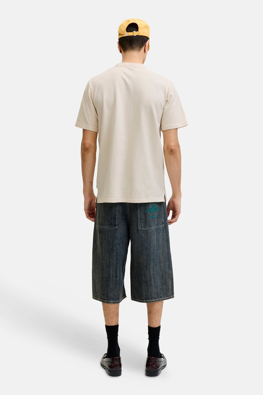 Beige korte mouwen t-shirt van PREMIUM by JACK & JONES, achterkant weergegeven, gestreept textuur, model draagt jeansshorts en gele pet