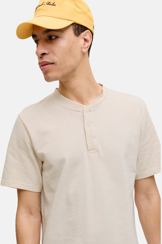 Beige korte mouwen T-shirt met knoopsluiting van PREMIUM by JACK & JONES, gestreept textuur, model draagt gele pet, zijprofiel.