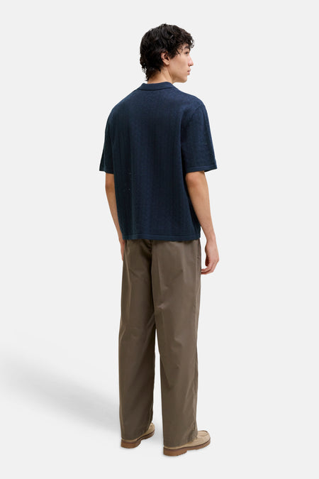 Polo bleu de ORIGINALS BY JACK & JONES avec un motif chevron tricoté, porté par un homme avec un pantalon marron, vue arrière.