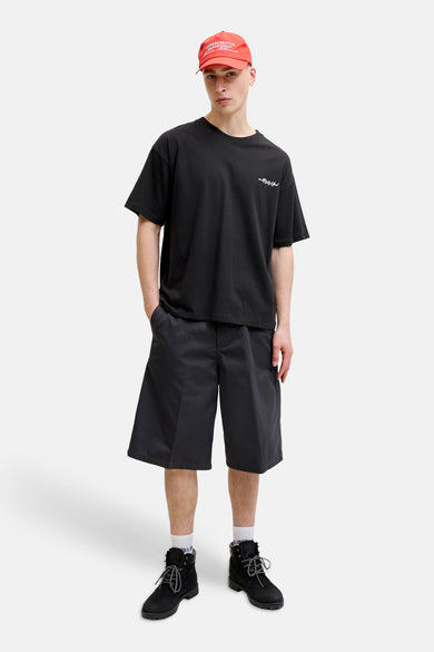 Zwart T-shirt met korte mouwen van CORE BY JACK & JONES, met witte 'mid99 Club' print op de borst, gecombineerd met donkere shorts en een rode pet.