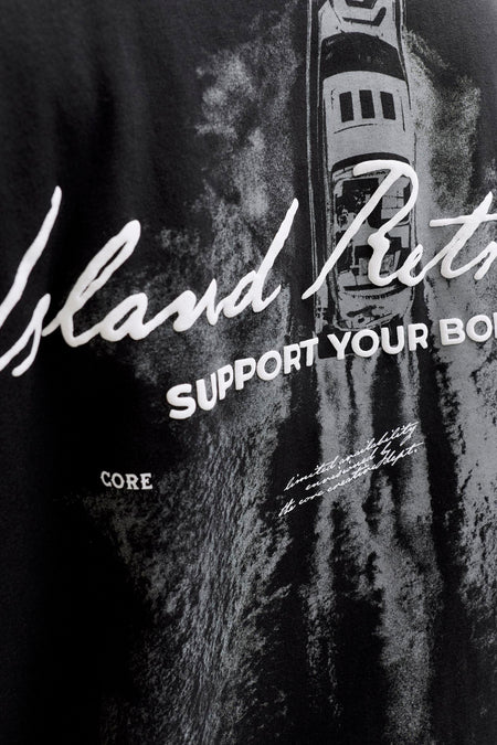 Zwart T-shirt met korte mouwen van CORE BY JACK & JONES met een witte grafische print van een boot en teksten, close-up.