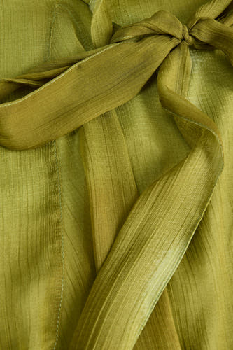 Groen mouwloos kleedje van JJXX met fijne rimpeltextuur en strikdetail, close-up van stof en zoom