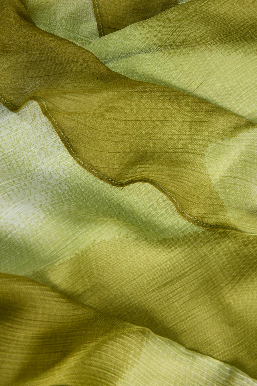 Groen mouwloos kleedje van JJXX, zacht geweven stof met subtiel patroon en golvende zoom, close-up detail