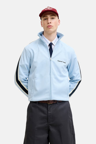 Blauw gilet van Originals by Jack & Jones met ritssluiting, gestreepte mouwen en logo, gedragen met overhemd, stropdas en rode pet.