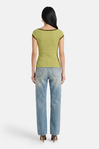 Groene ribbel t-shirt van JJXX, achterkant, met donkergroene randen, gedragen met lichtblauwe jeans en hoge hakken